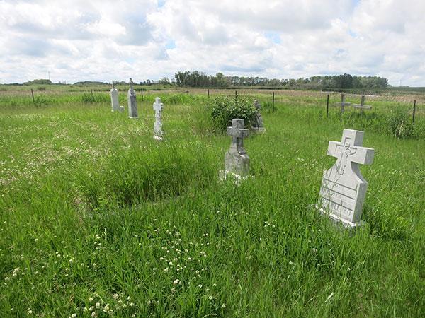 Rural prairie cemetery with white cross headstones